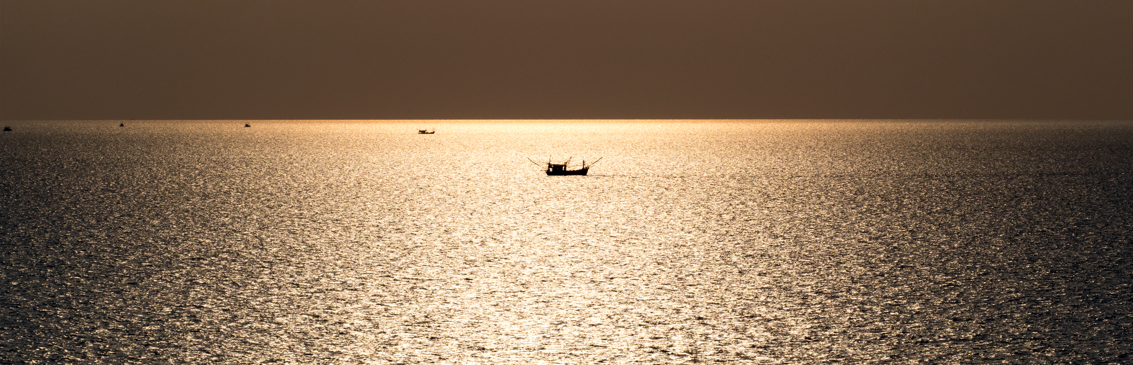 A boat on a calm golden sea